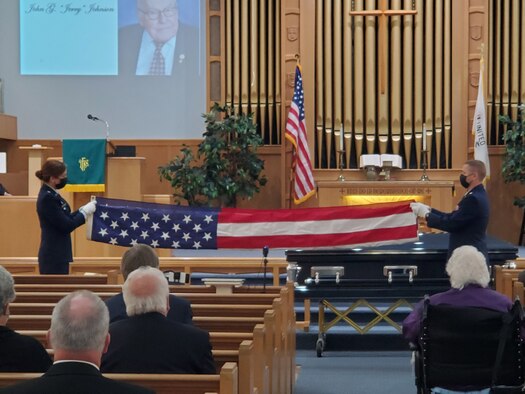 Lt. Col. (retired) Dianne Hickey, former 14th Intelligence Squadron commander, and Maj. Andrew Soine, 14 IS director of operations, fold a flag as part of the military honors conducted during World War II veteran John “Jerry” Johnson’s funeral Oct. 23, 2021. Senior Master Sgt. Jonathon Washington performed Taps during the service. Johnson had served in Guam during World War II with the Army Air Corps in the 20th Air Force 9th Photographic Technical Squadron. His squadron ultimately became the 14 IS.