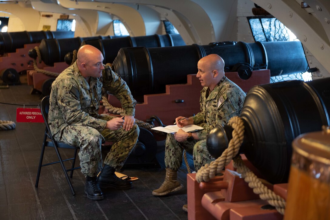 Master Chief Petty Officer of the Navy Russell Smith speaks with Chief (select) Legalman Brett Owens aboard the oldest commissioned warship afloat in the world, USS Constitution, during Chief Heritage Week as the ship gets underway.