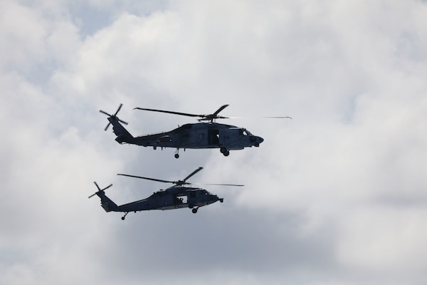 A U.S. Navy MH-60S Sea Hawk helicopter flies with helicopters from the Japan Maritime Self-Defense Force during a transit of the South China Sea.