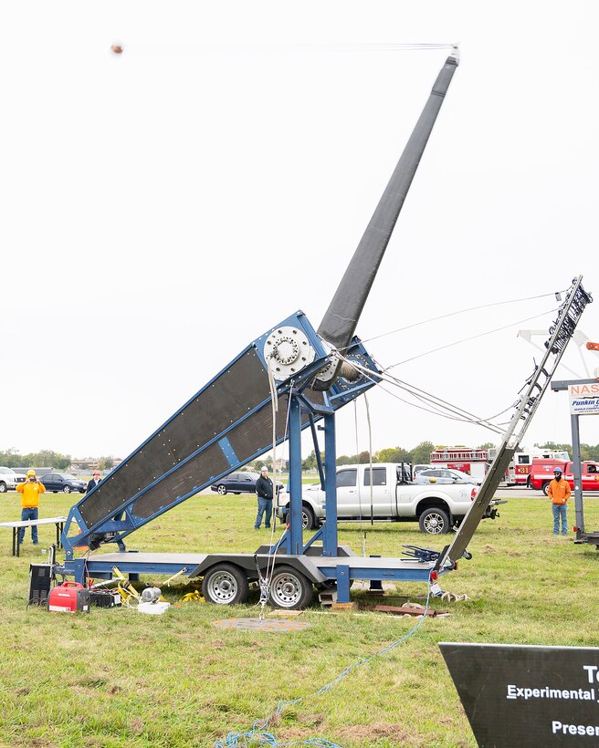 The Phoenix, an experimental torsion catapult, sends a pumpkin (upper left) 2,840 feet, more than a half-mile, downrange Oct. 22, 2021, during the 16th annual Pumpkin Chuck at Wright-Patterson Air Force Base, Ohio. The members of Team ETHOS, which built the Phoenix, are from the Dayton area and most either work at or are affiliated with Wright-Patt. (U.S. Air Force photo by R.J. Oriez)