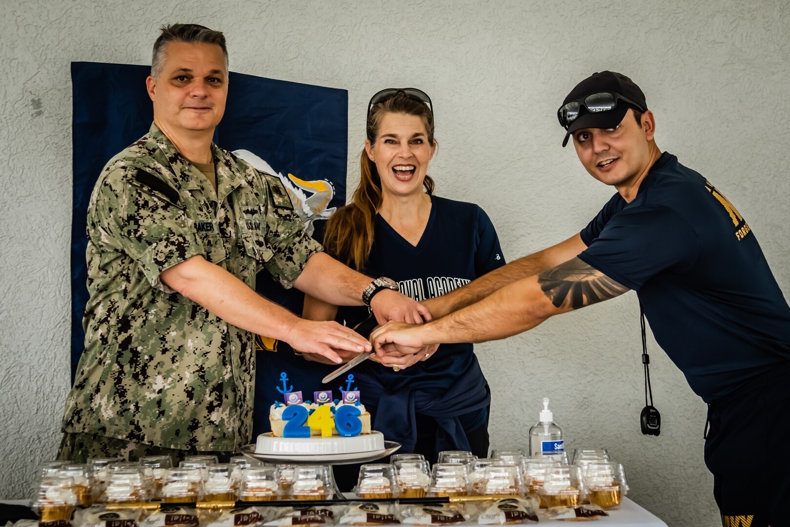 Three people cutting a cake