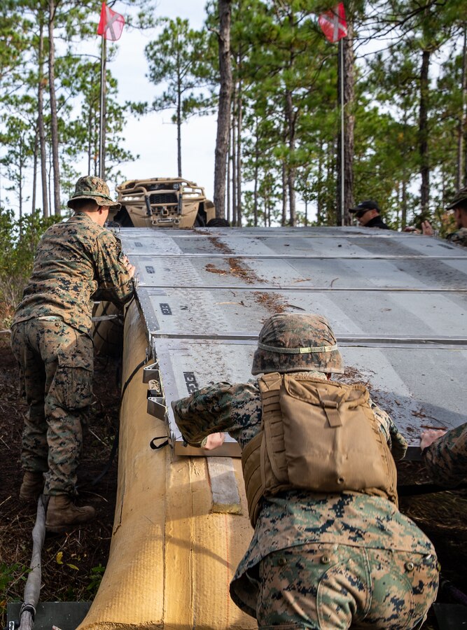 U.S. Marines with Engineer Platoon, 1st Battalion, 2d Marine Regiment, 2d Marine Division, adjust panels on an AirBeam Light-Weight Expeditionary Bridge during Expeditionary Military Trails Project at Camp Lejeune, N.C., Oct. 28, 2021.
