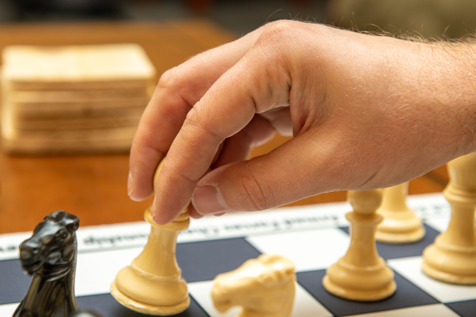 Airman 1st Class Charles Unruh, 28th Logistics Readiness Squadron distribution section chief, places a chess piece on a chess board at Ellsworth Air Force Base, S.D., Oct. 20, 2021. Unruh won four awards at the 62nd Annual U.S. Armed Forces Open Chess Championship as well as a commemorative chess board for the event. (U.S. Air Force photo by Airman 1st Class Quentin K. Marx)