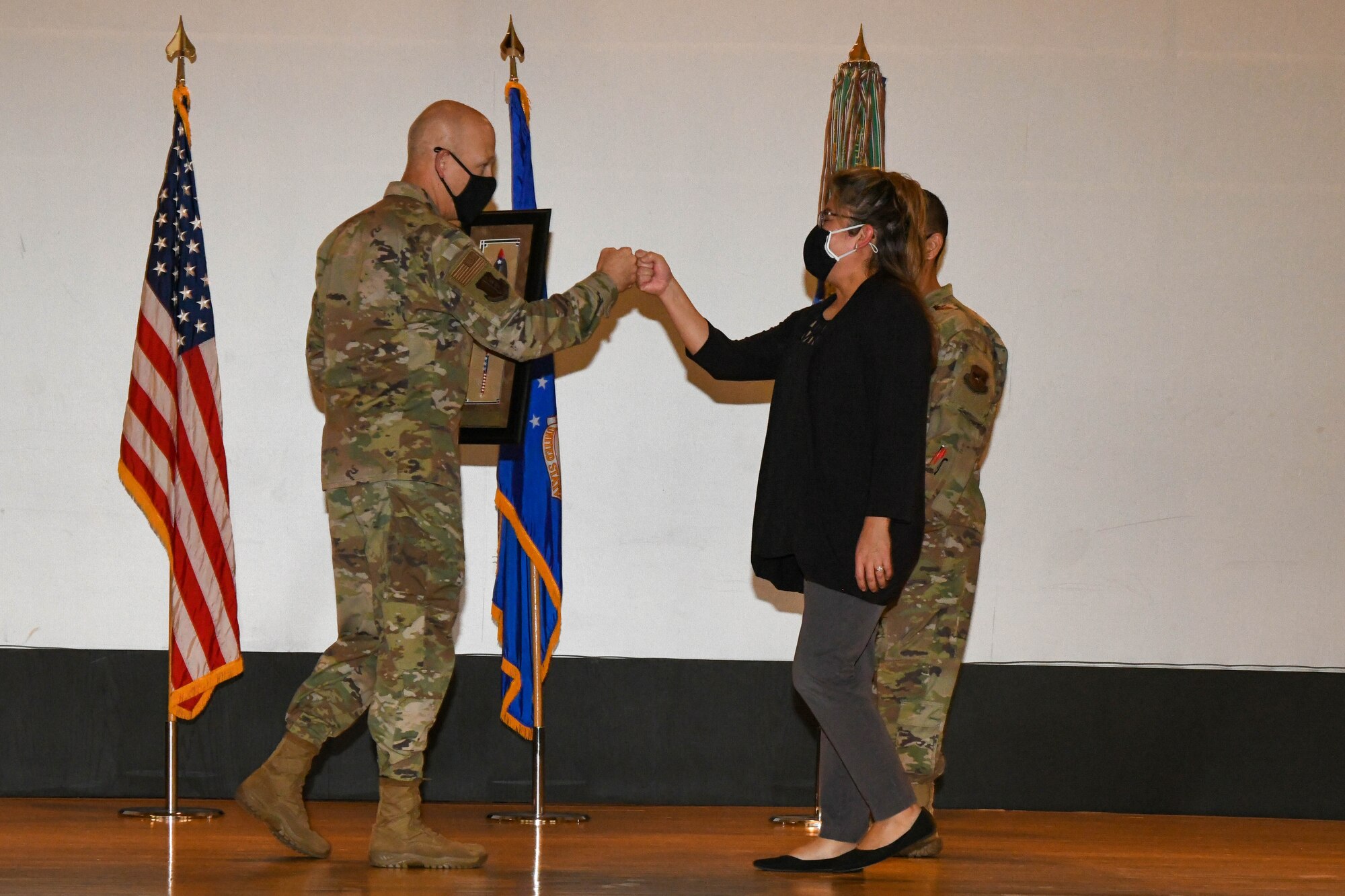 Rosemary Cook, 97th Operations Support Squadron commander’s secretary, fist bumps Col. Blaine Baker, 97th Air Mobility Wing commander, after being called to the stage during an awards ceremony on Altus Air Force Base, Oklahoma, Oct. 19, 2021. Cook was one of ten winners of the Society of American Indian Government Employees Military Meritorious Service Award, out of more than 3,000 nominees. (U.S. Air Force photo by Airman 1st Class Trenton Jancze)