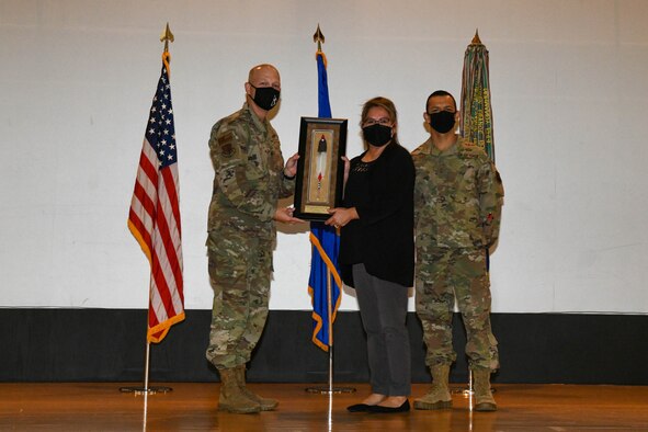 Rosemary Cook, 97th Operations Support Squadron commander’s secretary, poses with Col. Blaine Baker, 97th Air Mobility Wing commander, and Chief Master Sgt. Caesar Flores, 97th AMW command chief, during an awards ceremony on Altus Air Force Base, Oklahoma, Oct. 19, 2021. Cook was awarded the Society of American Indian Government Employees Military Meritorious Service Award for her accomplishments for  the squadron, group, and wing. (U.S. Air Force photo by Airman 1st Class Trenton Jancze)