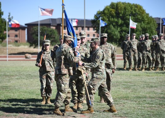 U.S. Army Master Sgt. Christopher Varner, outgoing 344th Military Intelligence Battalion acting command sergeant major, passes the colors to Lt. Col. Joseph Garwacki, 344th MI BN commander, during the change of responsibility ceremony Oct. 28, 2021, at Goodfellow Air Force Base, Texas. Varner served in the 344th MI BN as the senior enlisted leader for the past year. (U.S. Air Force photo by Staff Sgt. Tyrell Hall)