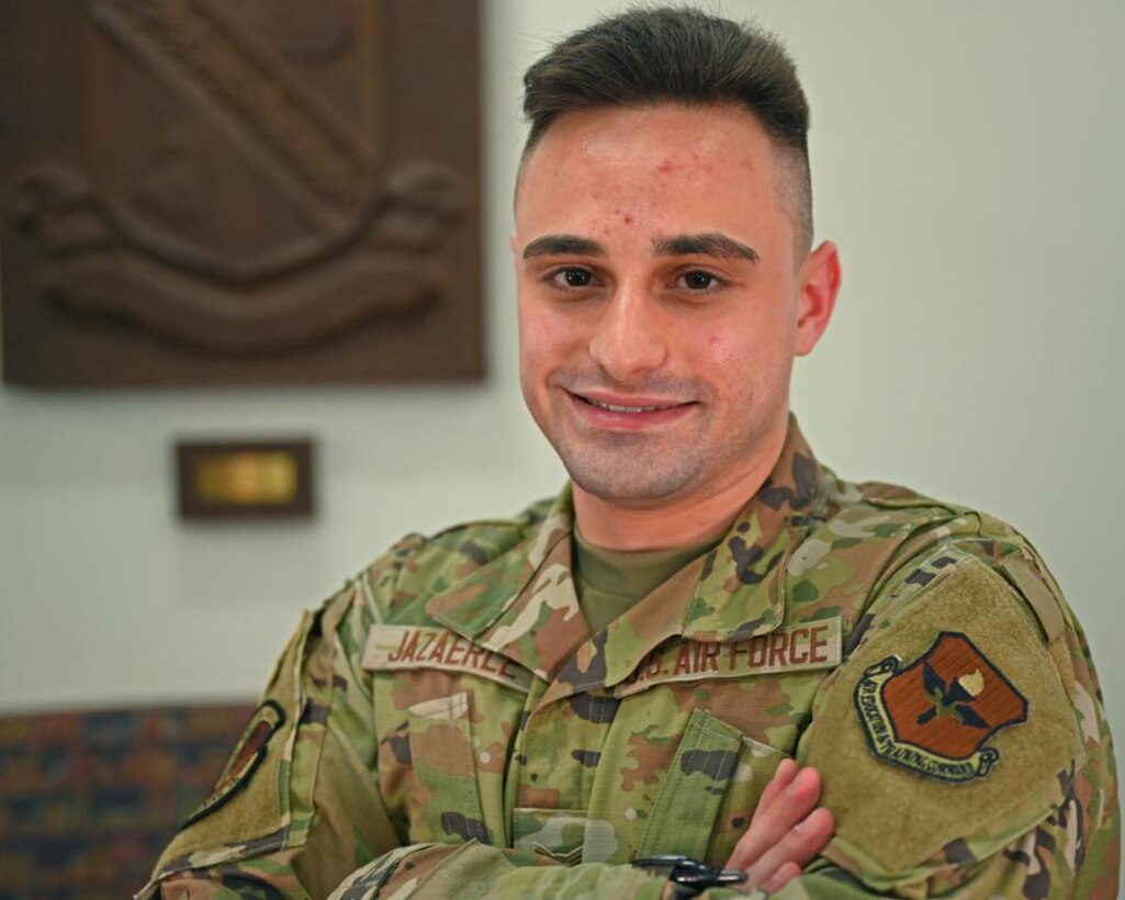 Airman 1st Class Omar Jazaerle poses in front of the Defense Language Institute crest in the Aiso Library on Presidio of Monterey, CA., July 23, 2021. The Aiso Library serves as a hub for DLI students to study their target language in a calm quiet setting after class each day. (U.S. Air Force photo by Senior Airman Michael Bowman)