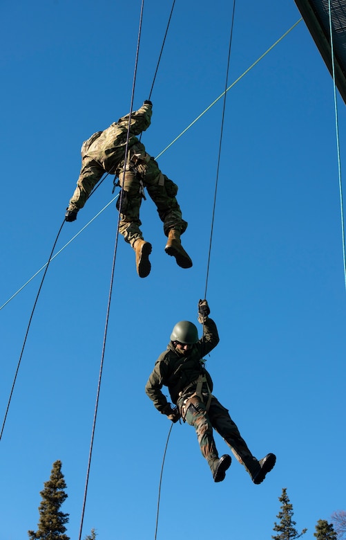 Two men hold onto ropes.