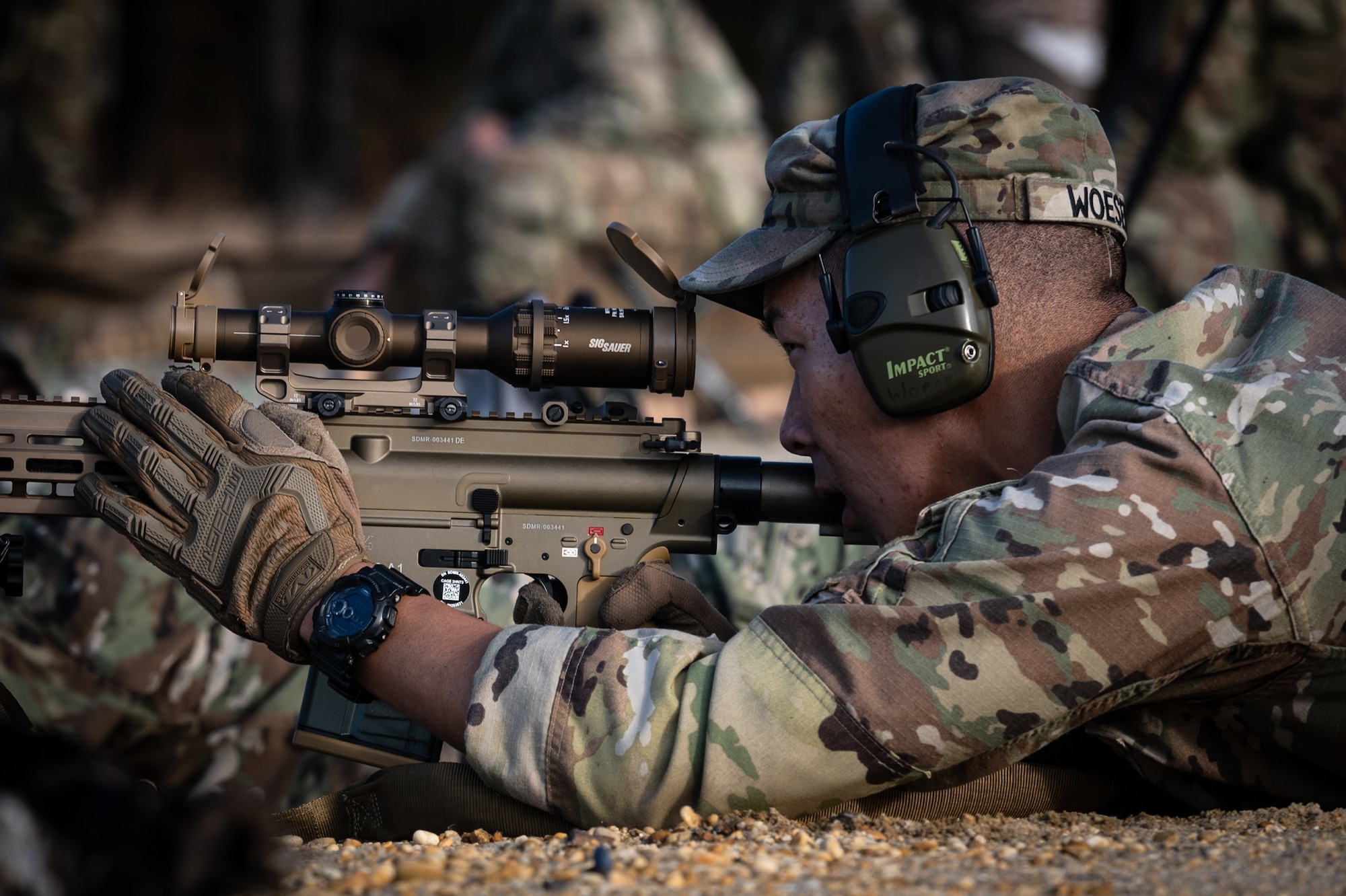 Soldier looks through scope of rifle