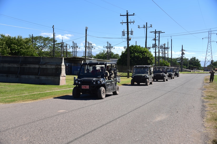 A convoy of troops passes an area of power lines.