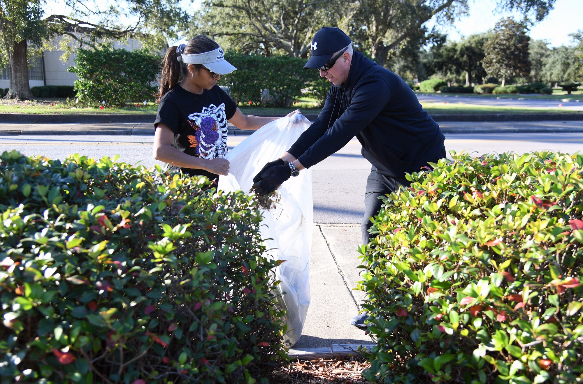 U.S. Air Force Col. William Hunter, 81st Training Wing commander, and his wife, Blanca, participate in Base Cleanup Day on Meadows Ave. at Keesler Air Force Base, Mississippi, Oct. 29, 2021. Base leadership joined Airmen to clean up around the base to inspire beautification. (U.S. Air Force photo by Kemberly Groue)