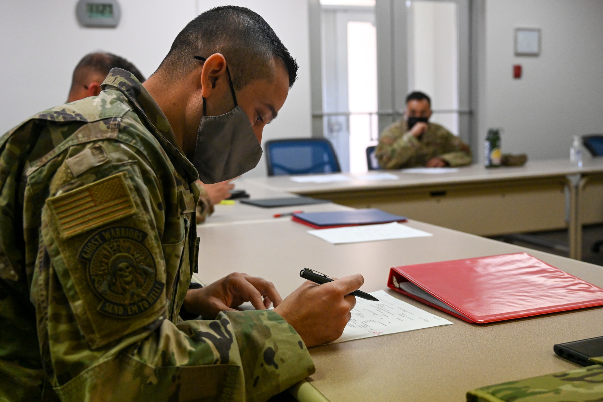 A senior enlisted member reviews a performance report at the Tech. Sgt. Records, Oct. 18, 2021, on Holloman Air Force Base, New Mexico. Technical sergeants broke out into groups with senior enlisted members to get direct feedback on their records. (U.S. Air Force photo by Airman 1st Class Adrian Salazar)