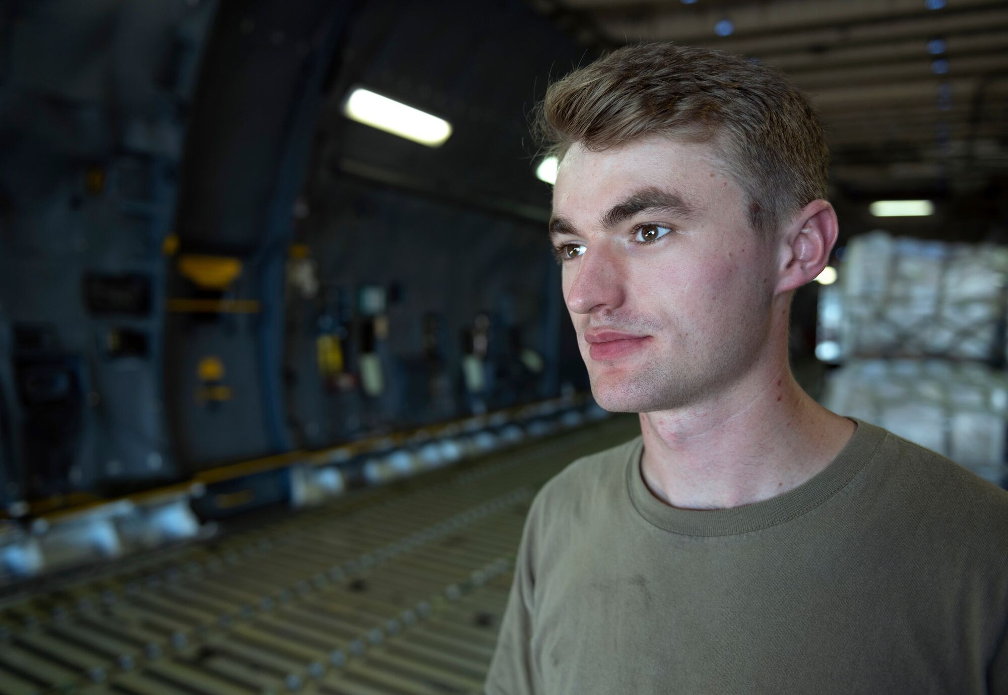 An Airman looks out inside of a C-5 cargo bay