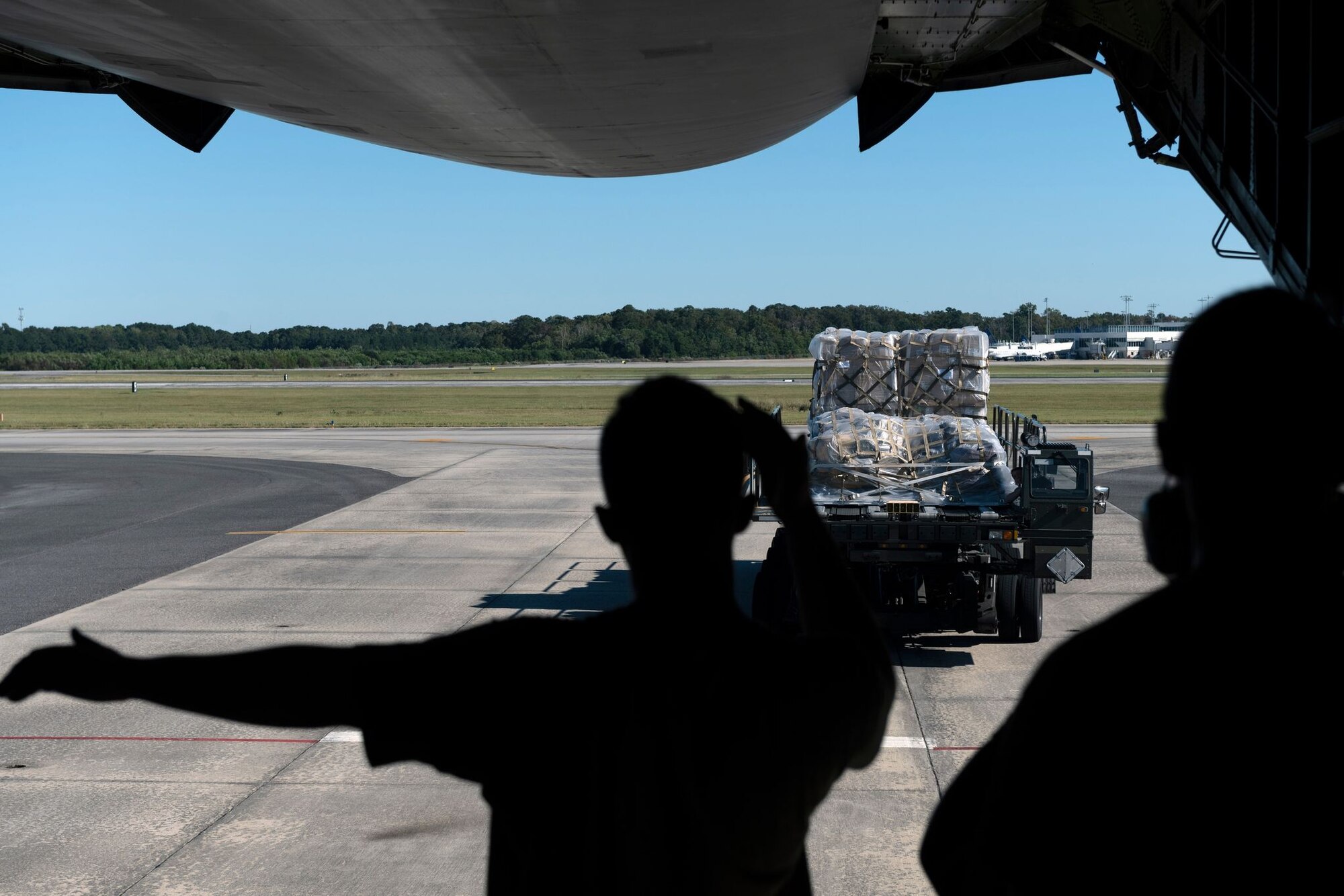 An Airman directs a k-loader to the back of an open C-5 cargo door