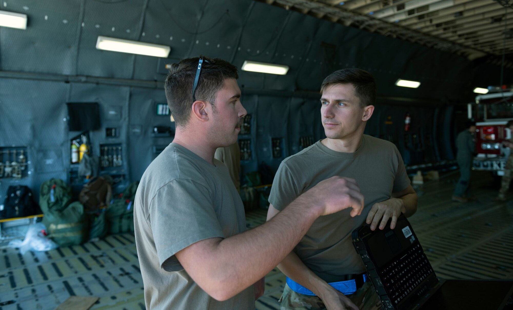 Two Airmen speak inside of a C-5 cargo hold
