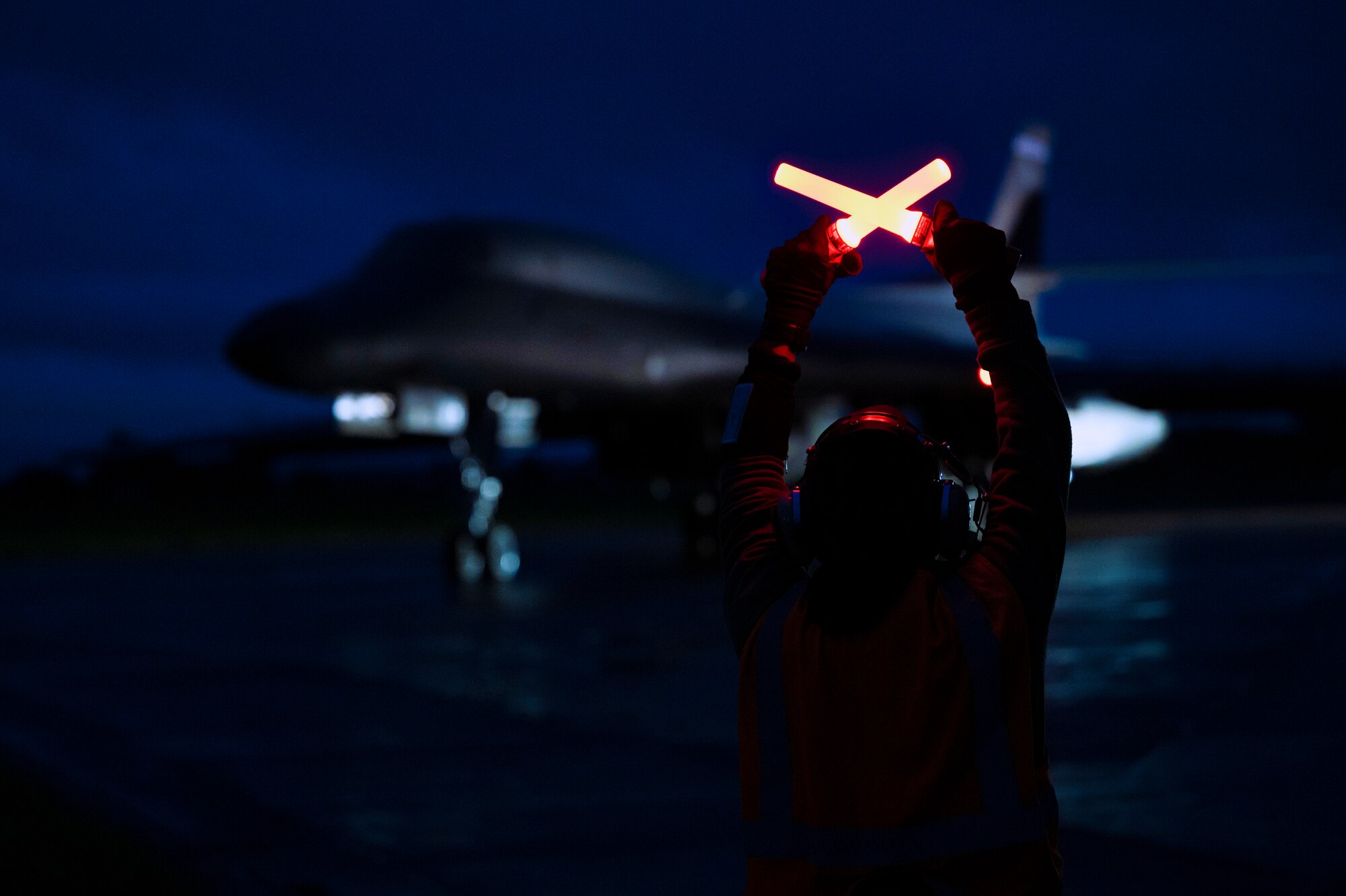 A crew chief assigned to the 9th Expeditionary Bomb Squadron prepares to marshal a B-1B Lancer during a Bomber Task Force Europe mission.