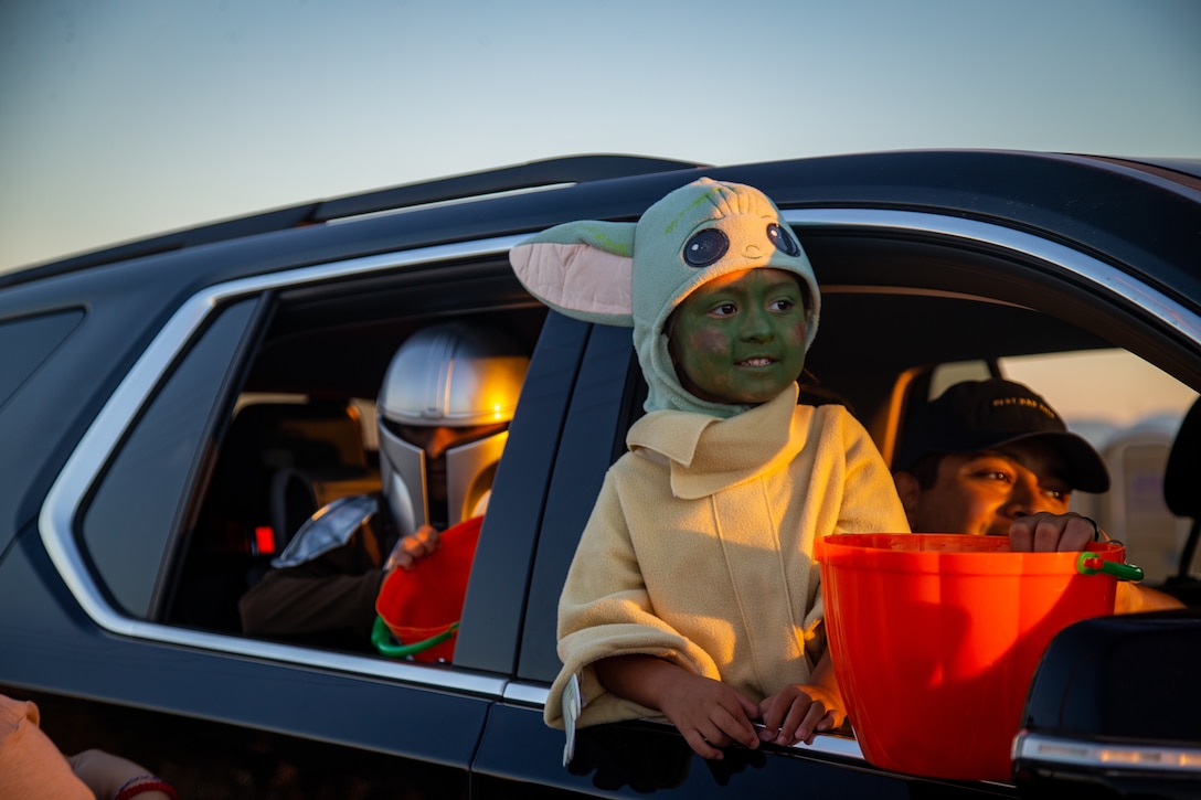 Children collect candy during the 7th Annual Red Ribbon Trunk or Treat at Marine Corps Air Station Yuma, Ariz., Oct. 28, 2021. The event created a fun and safe environment for Marines and their families to celebrate Halloween while promoting a drug free Marine Corps. (U.S. Marine Corps photo by Cpl. Gabrielle Sanders)