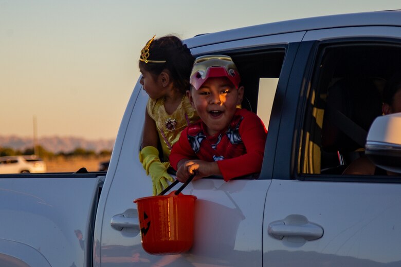 Children collect candy during the 7th Annual Red Ribbon Trunk or Treat at Marine Corps Air Station Yuma, Ariz., Oct. 28, 2021. The event created a fun and safe environment for Marines and their families to celebrate Halloween while promoting a drug free Marine Corps. (U.S. Marine Corps photo by Cpl. Gabrielle Sanders)