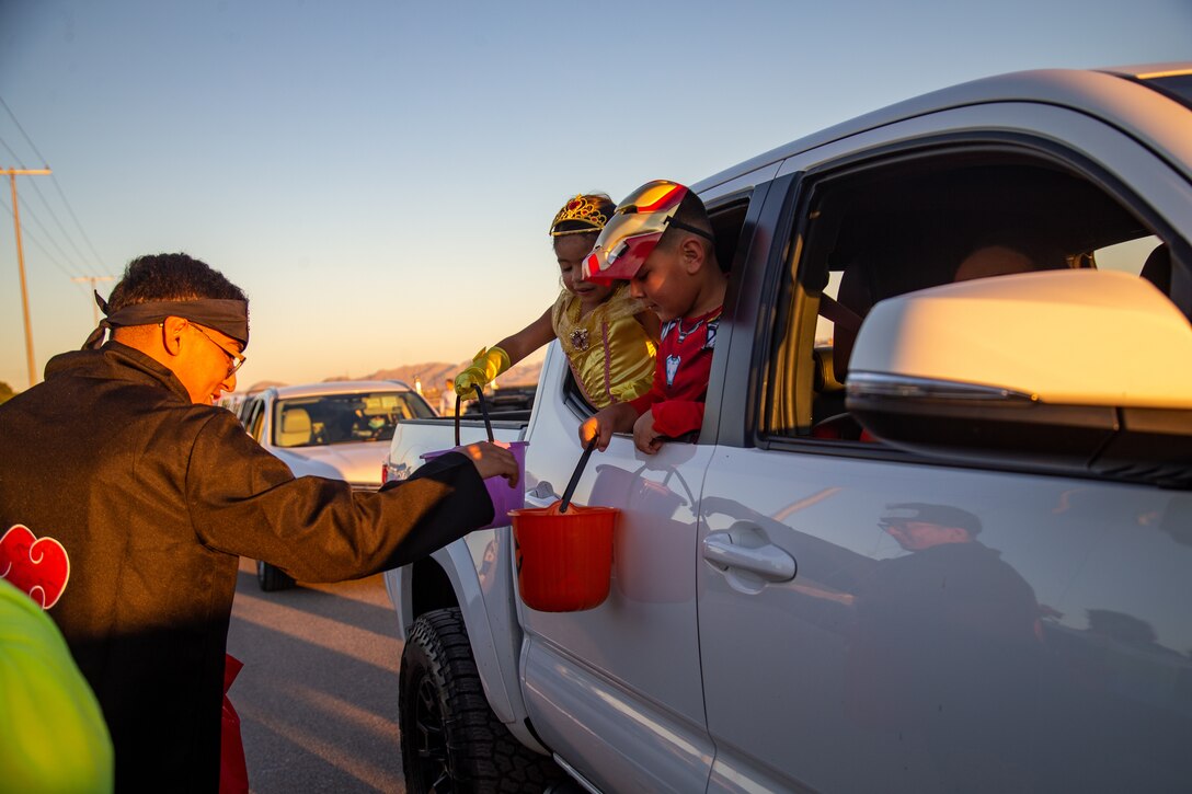 Service members and participants pass out candy to children and families during the 7th Annual Red Ribbon Trunk or Treat at Marine Corps Air Station Yuma, Ariz., Oct. 28, 2021.