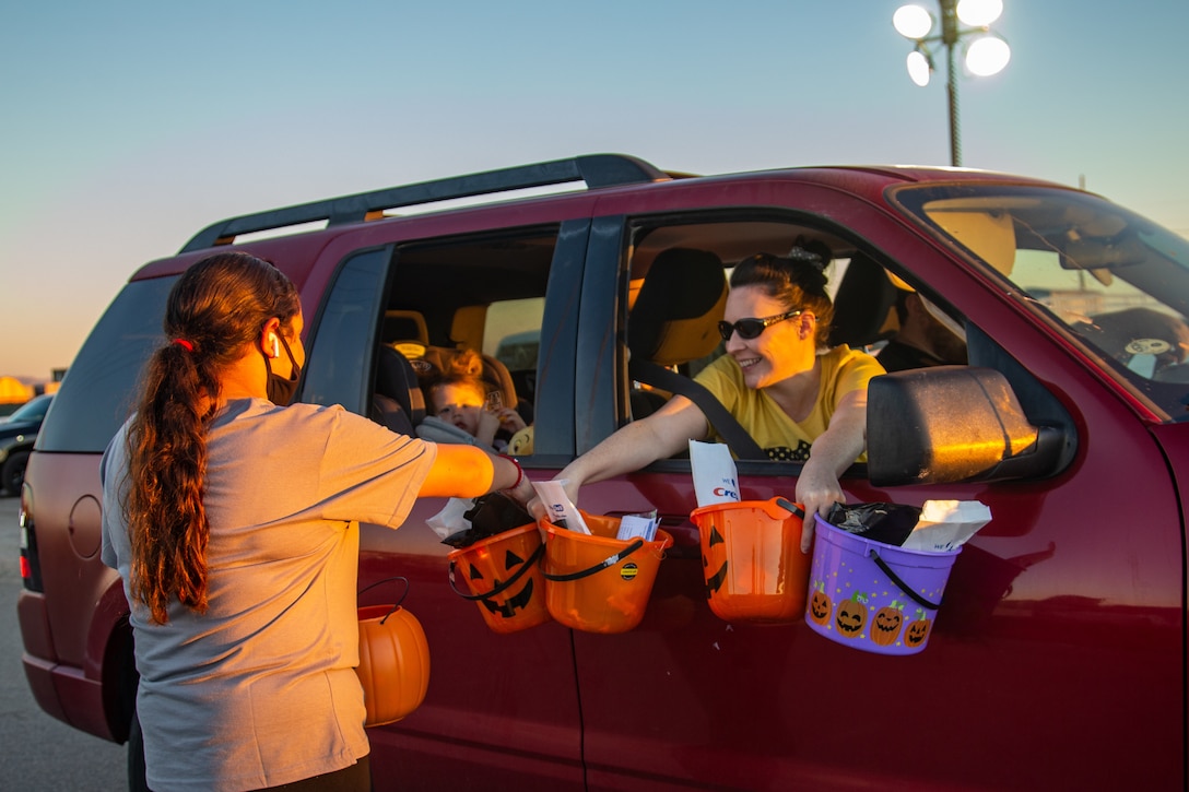 Service members and participants pass out candy to children and families during the 7th Annual Red Ribbon Trunk or Treat at Marine Corps Air Station Yuma, Ariz., Oct. 28, 2021.