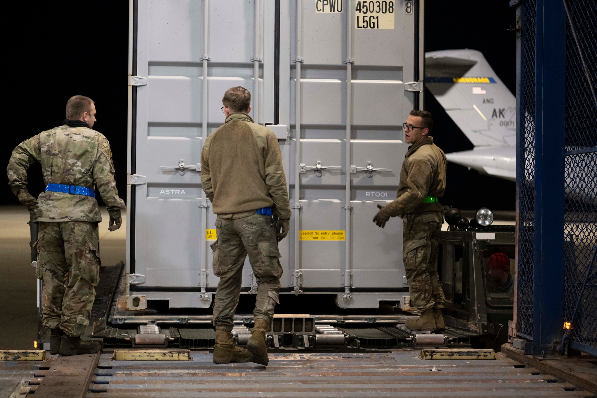 Airman stand by shipping container