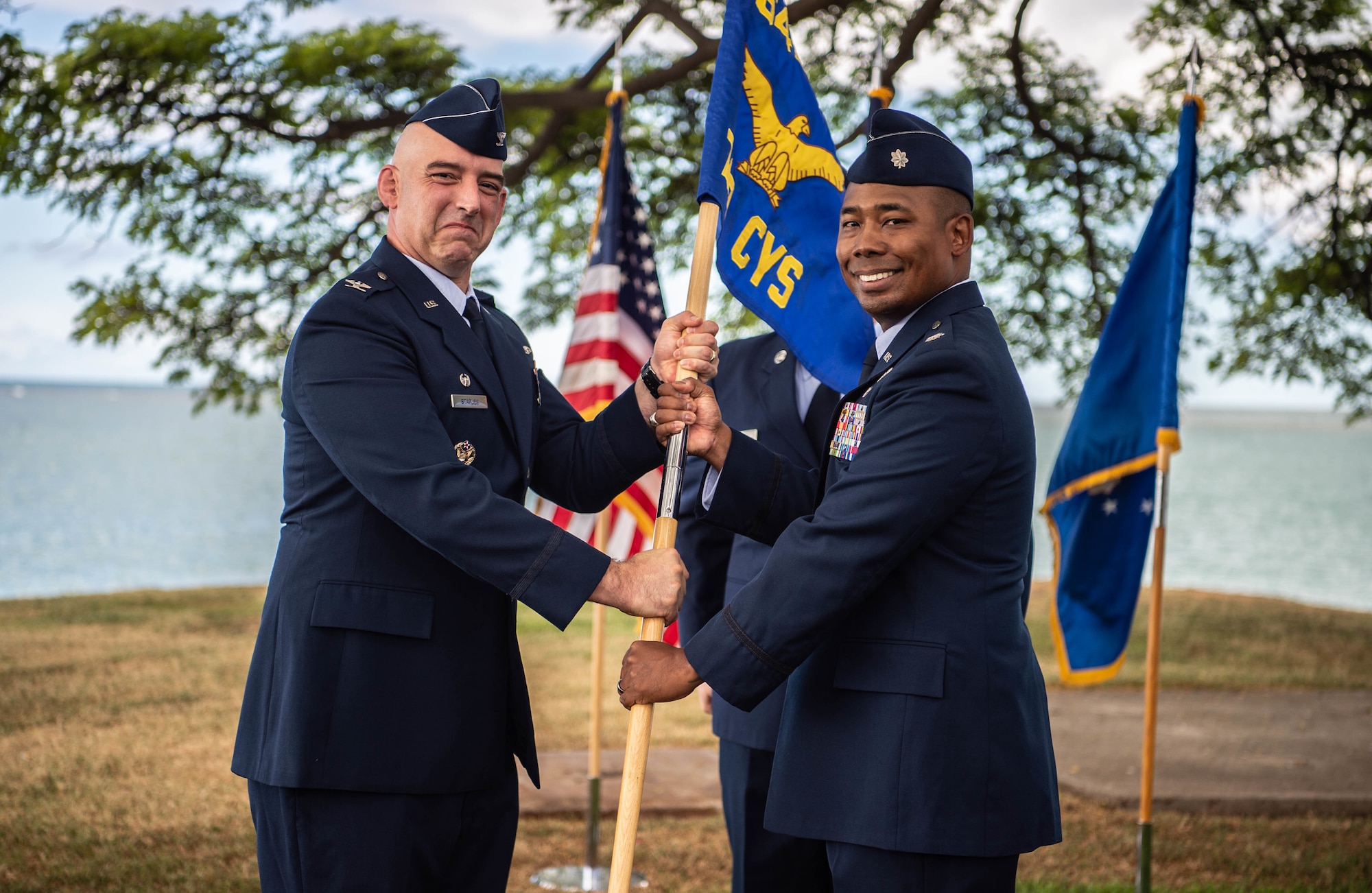 Col. Michael Staples, 647th Air Base Group commander and Joint Base Pearl Harbor-Hickam deputy commander, holds the new 747th Cyberspace Squadron guidon with Lt. Col. Michael Brewer, 747th Cyberspace Squadron commander, during a redesignation ceremony at JBPHH, Hawaii, Oct. 29, 2021. The 747th CYS met all prerequisite qualifications to host a mission defense team that will support cyber defense missions. (U.S. Air Force photo by Senior Airman Alan Ricker)