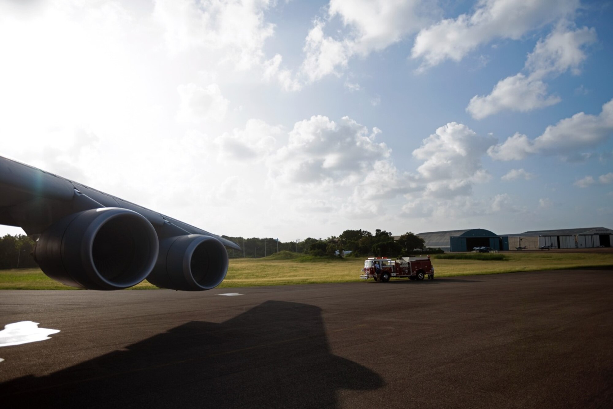 A firetruck sits next to a C-5 on a flight line on a sunny day