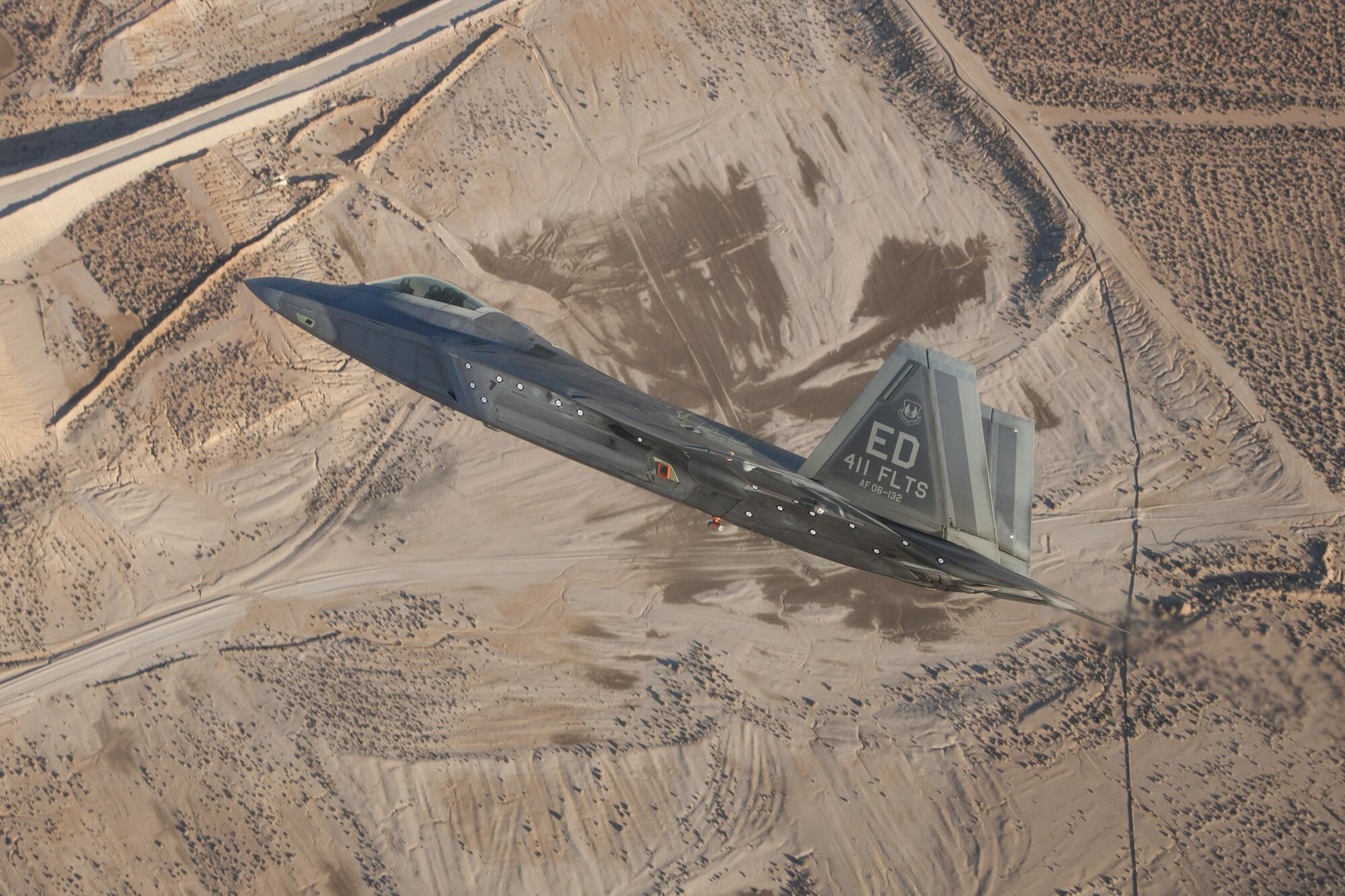 An F-22 Raptor assigned to the 411th Flight Test Squadron maneuvers over the Mojave Desert during a test mission. (Photo by Chad Bellay/Lockheed Martin)