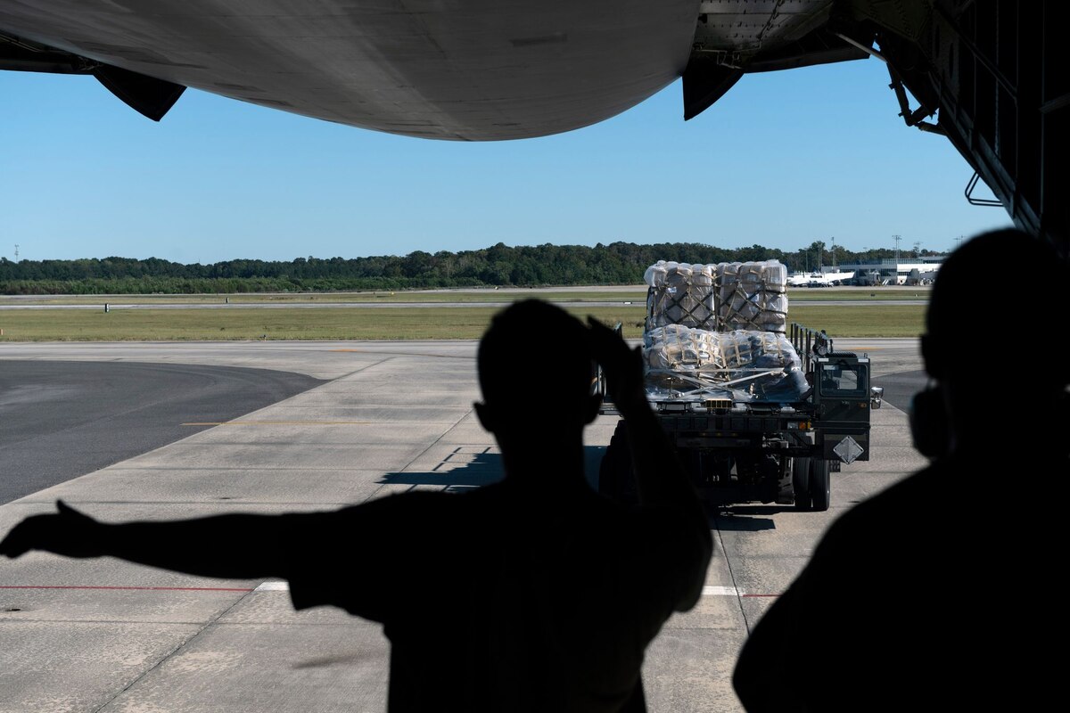 Airman 1st Class Daniel Taylor, 22nd Airlift Squadron loadmaster, guides a K-loader toward a C-5M Super Galaxy at Joint Base Charleston, S.C., Oct. 26, 2021. The 22nd AS received more than 56,000 pounds of humanitarian cargo destined for San Isidro Air Base, Dominican Republic.
