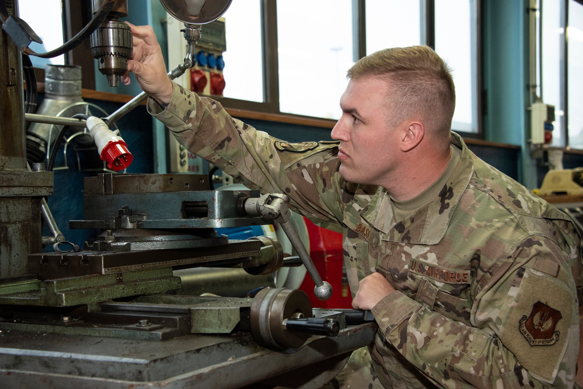 U.S. Air Force Staff Sgt. Jacob Bass, 52nd Fighter Wing Safety Office occupational safety technician, inspects a drill press that has been removed from service due to a lack of machine safety guards on Spangdahlem Air Base, Germany, Oct. 27, 2021. The occupational safety profession inspects base facilities and equipment and provides education and training to ensure work centers are safe. (U.S. Air Force photo by Staff Sgt. Chance Nardone)
