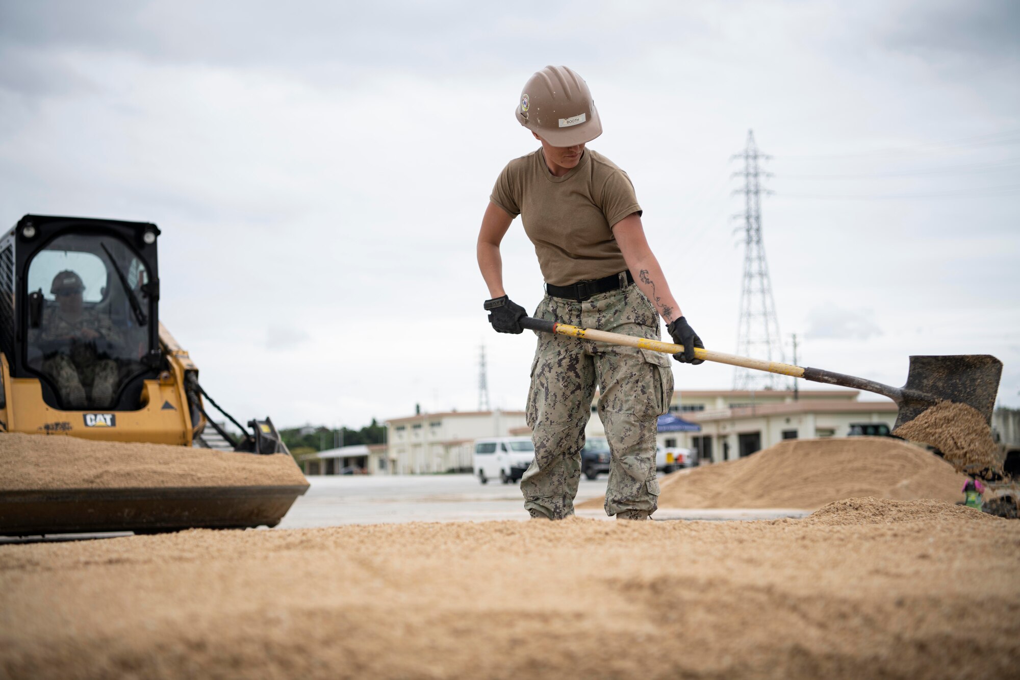 U.S. Navy member shovels dirt.