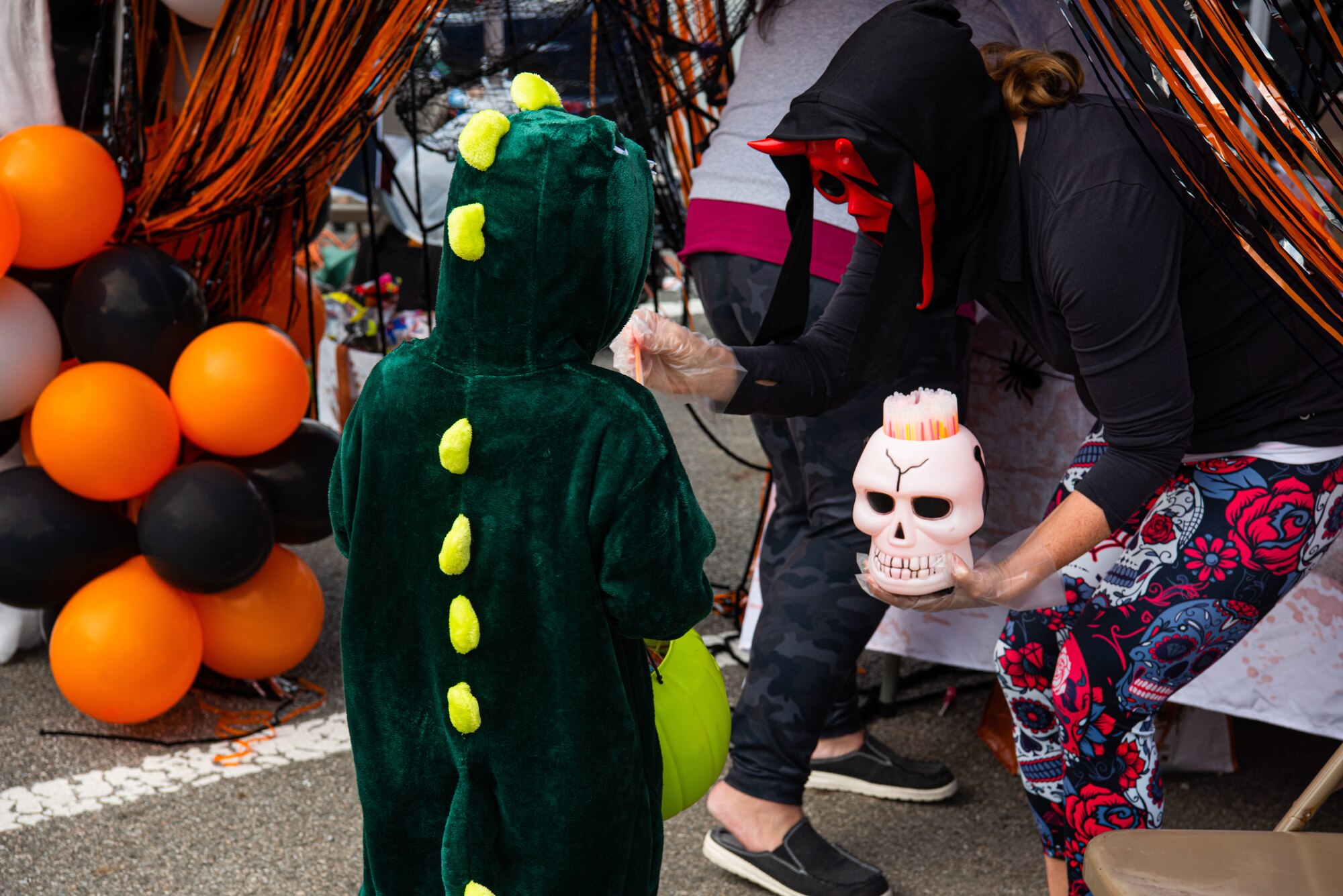 A volunteer passes out candy to an attendee of the Fall Festival & Trunk or Treat event hosted by the 51st Force Support Squadron Oct. 30, 2021, at Osan Air Base, Republic of Korea.
