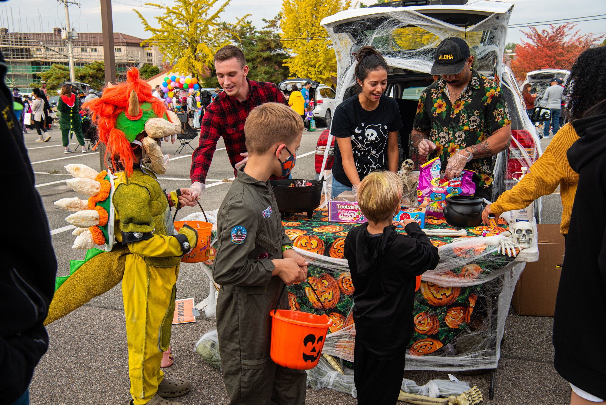 Volunteers pass out candy to attendees of the Fall Festival & Trunk or Treat event hosted by the 51st Force Support Squadron Oct. 30, 2021, at Osan Air Base, Republic of Korea.