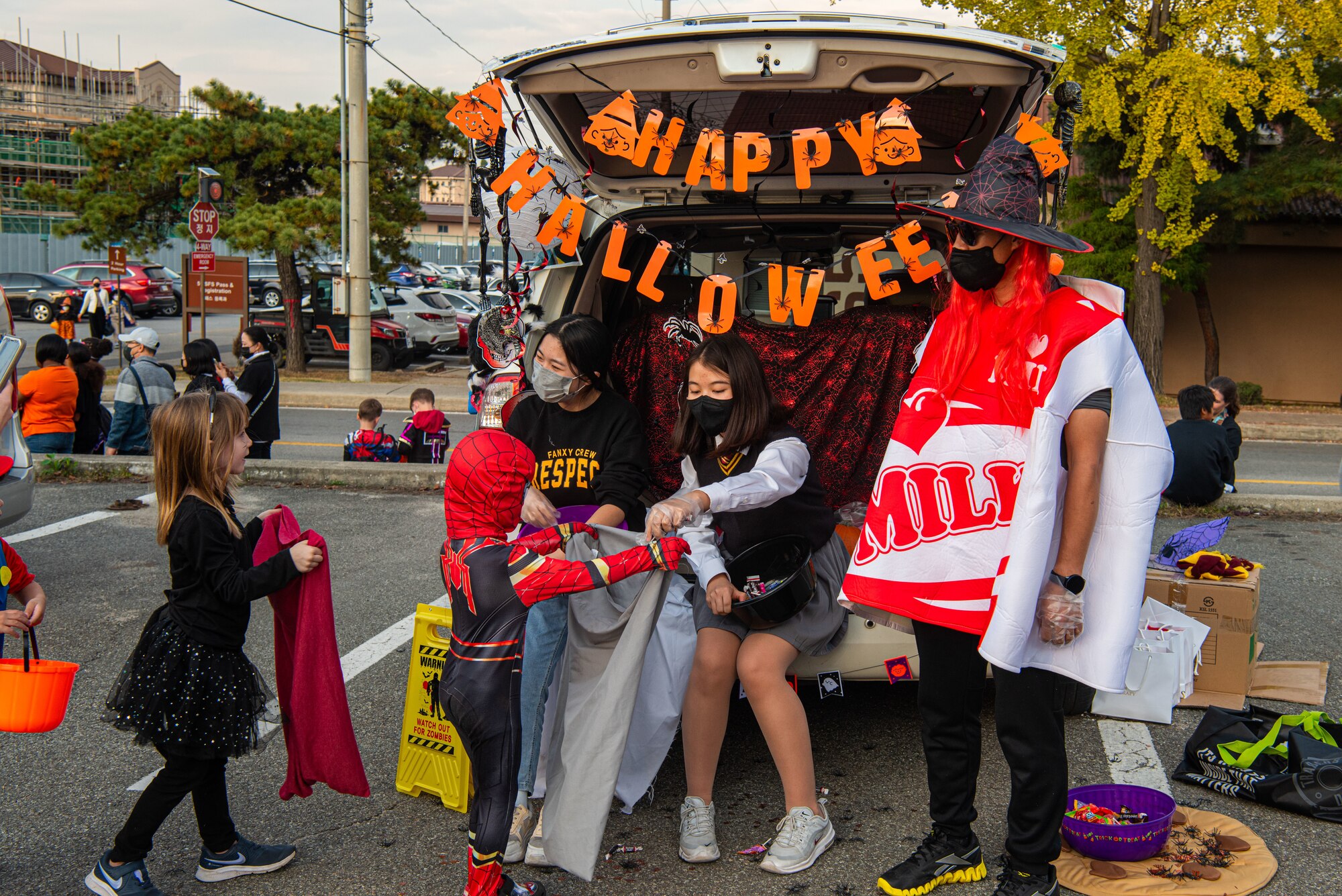 Volunteers pass out candy to attendees of the Fall Festival & Trunk or Treat event hosted by the 51st Force Support Squadron Oct. 30, 2021, at Osan Air Base, Republic of Korea.