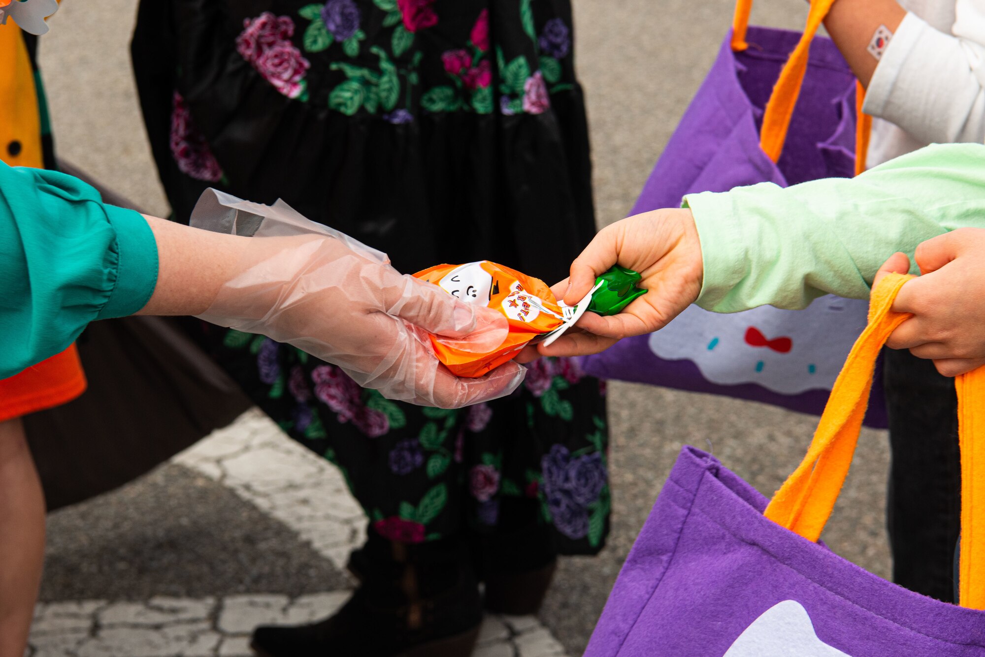 Volunteers pass out candy to attendees of the Fall Festival & Trunk or Treat event hosted by the 51st Force Support Squadron Oct. 30, 2021, at Osan Air Base, Republic of Korea.