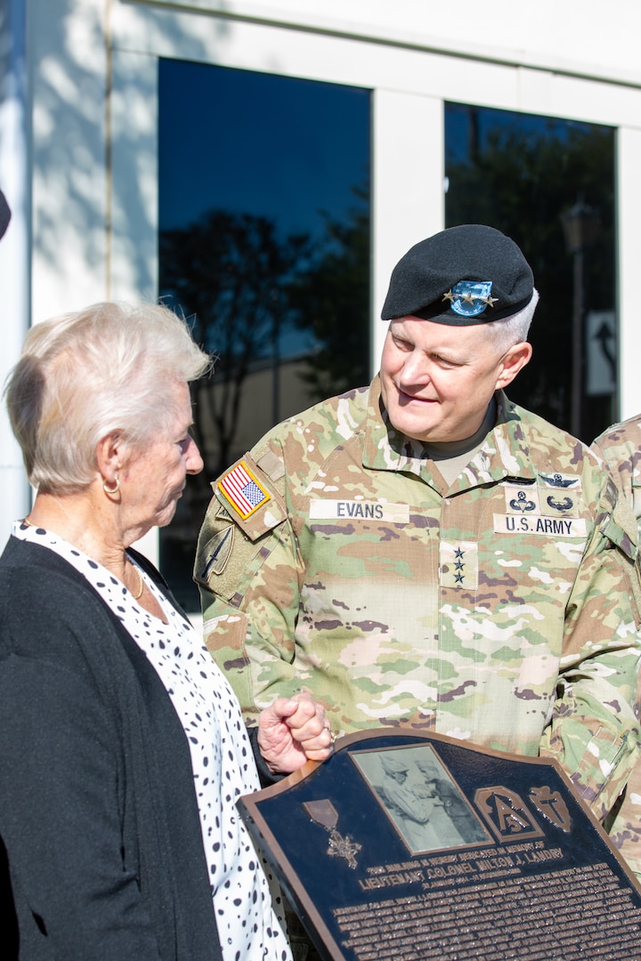 General and woman with memorial plaque.