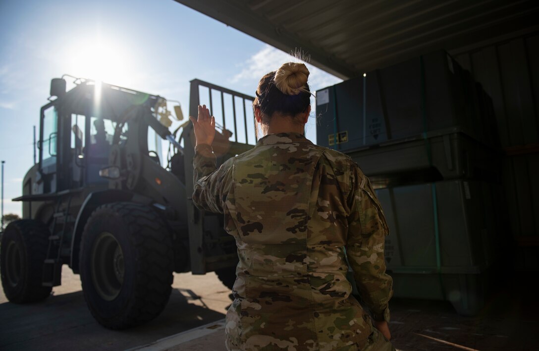Airman 1st Class Emily Louie, 8th Maintenance Squadron stockpile management technician, signals to Airman 1st Class Mikala Correa, 8th MXS stockpile management technician, during munitions unloading at Kunsan Air Base, Republic of Korea, Oct. 29, 2021. Munitions Airmen work with extreme care to handle, store, transport, arm and disarm weapons systems. (U.S. Air Force photo by Staff Sgt. Suzie Plotnikov)