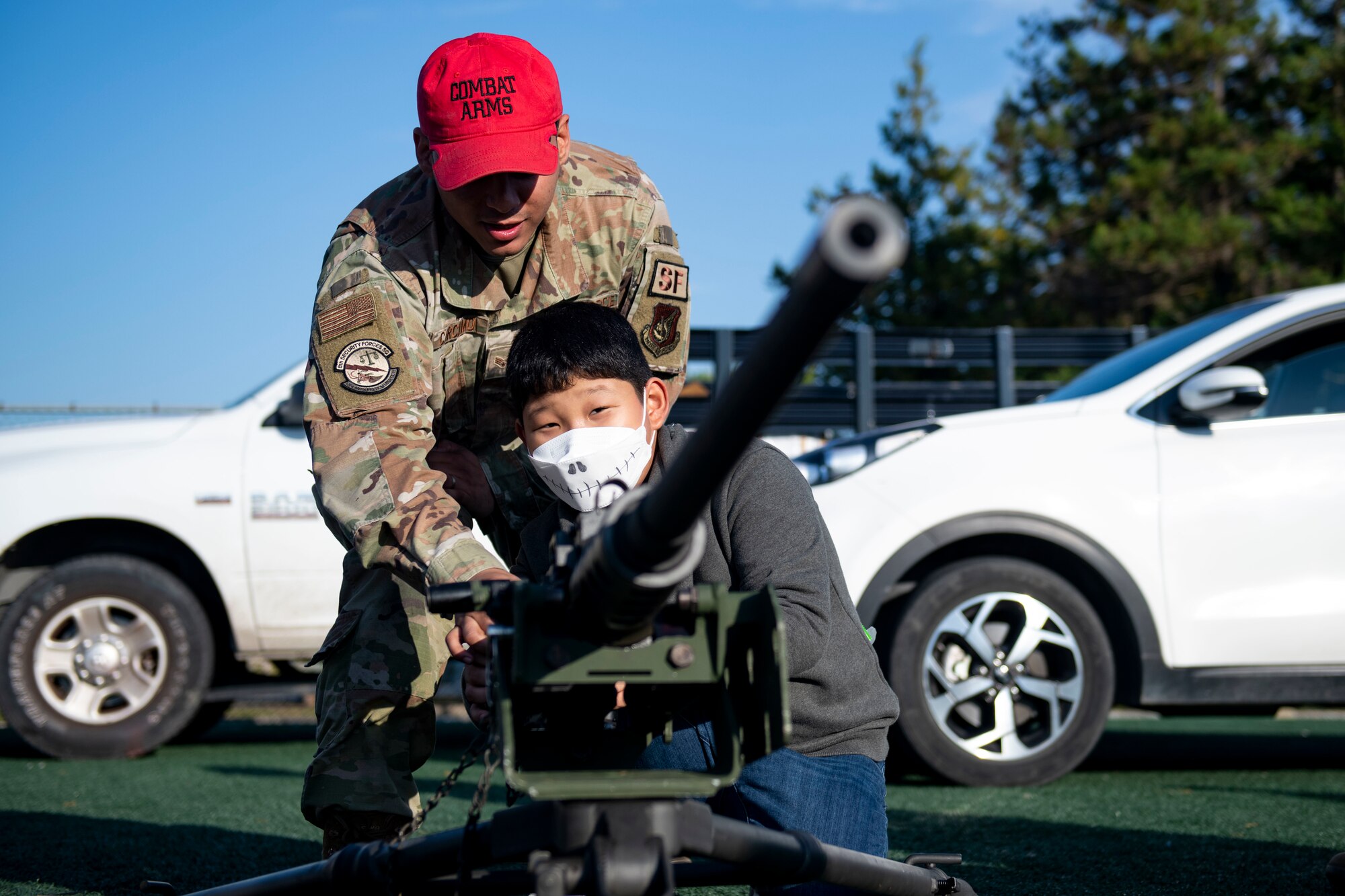 Senior Airman Bryan Carcamo, 8th Security Forces Squadron combat arms instructor demonstrates the M2 Browning .50 caliber to a Republic of Korea national child during Kunsan’s Annual Halloween Trick-or-Treat at Kunsan Air Base, Republic of Korea, October, 28, 2021. The 8th Civil Engineer Squadron hosted this years event which was open to all U.S. Military and South Korean Nationals with base access. (U.S. Air Force photo by Staff Sgt. Jesenia Landaverde)