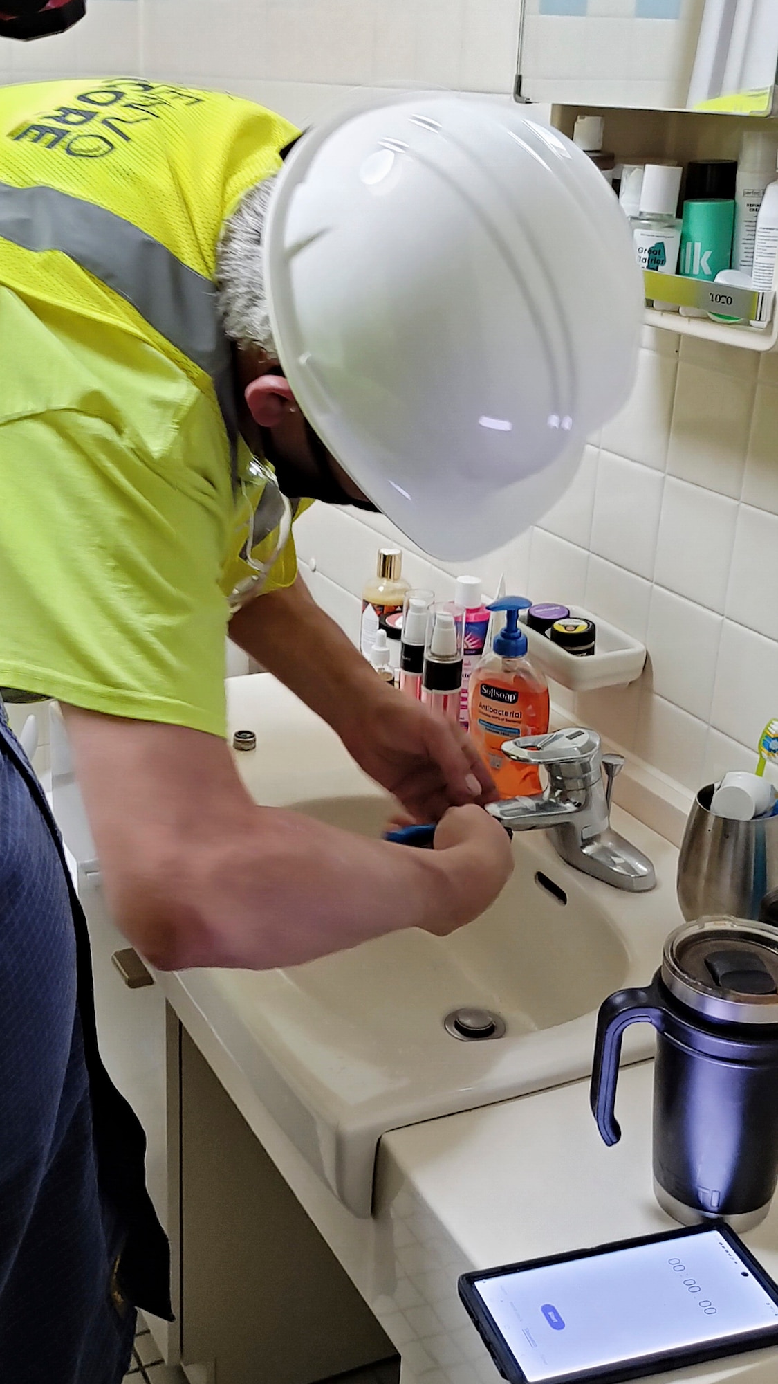 contractor works on installing a water saving fixture in a residence