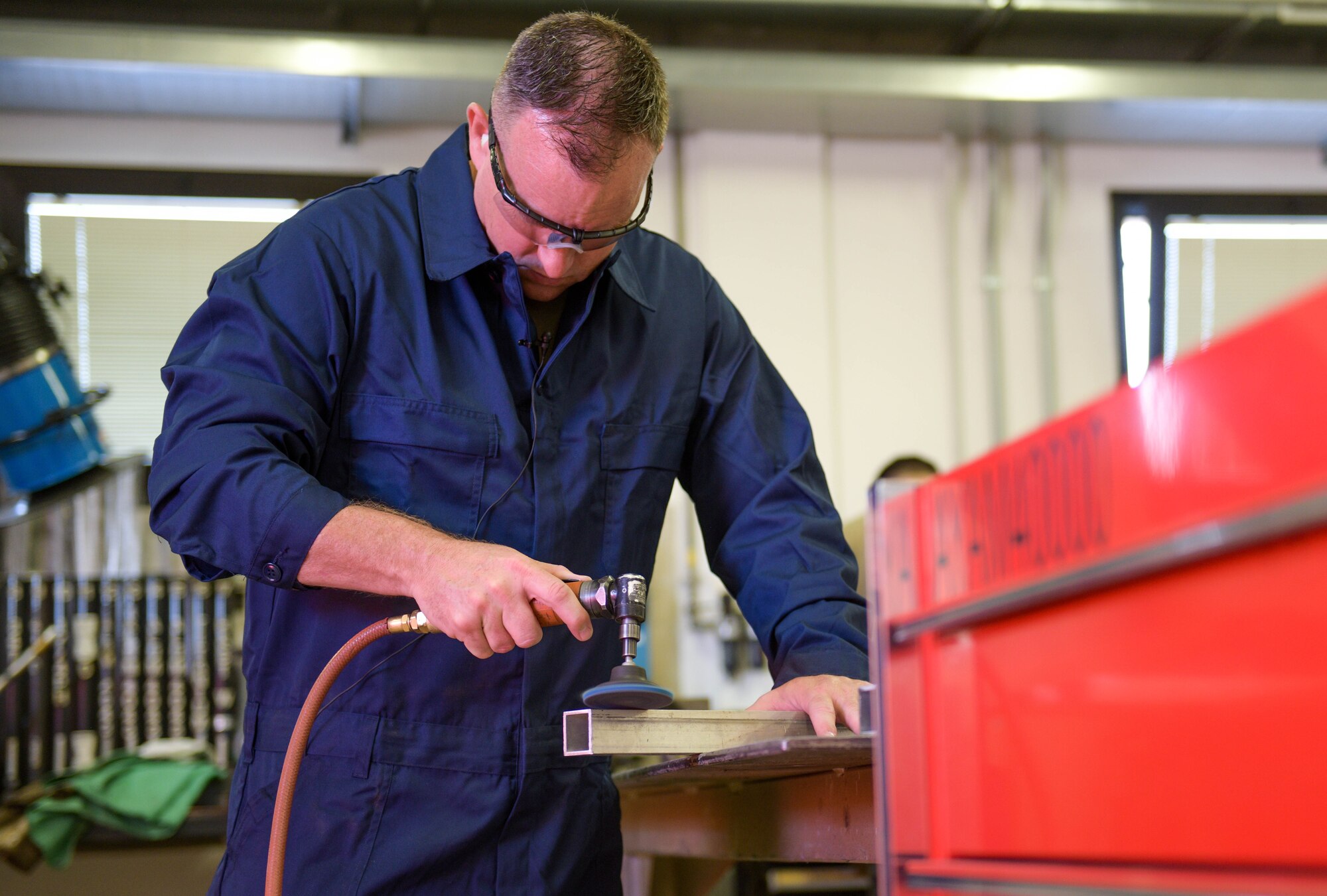 Chief Master Sgt. Jeremy L. Unterseher, 31st Fighter Wing command chief, cleans off a metal leg before welding it at Aviano Air Base, Italy, Aug. 30, 2021. Serving as the wing's senior enlisted leader, Unterseher is the principal advisor to the commander on matters influencing the readiness and professional development of approximately 4,200 active-duty military members, nearly 300 U.S. civilians and 700 Italian civilian employees. Unterseher and U.S. Air Force Brig. Gen. Jason E. Bailey, 31st FW commander, regularly tour around Aviano Air Base to get hands-on experience with the Airmen and learn their jobs. (U.S. Air Force photo by Senior Airman Brooke Moeder)
