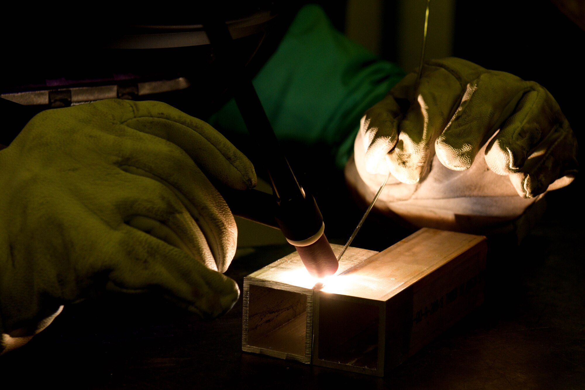 Chief Master Sgt. Jeremy L. Unterseher, 31st Fighter Wing command chief, welds two pieces of metal together at Aviano Air Base, Italy, Aug. 30, 2021. From troubleshooting to final fitting metal, technicians weld, fabricate and custom-make the metal components for aircraft. (U.S. Air Force photo by Senior Airman Brooke Moeder)