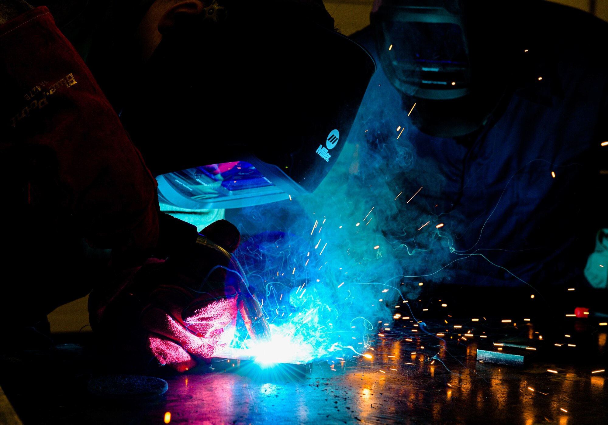 Senior Airman Joshuah Fonteno, 31st Maintenance Squadron metals technician journeyman, left, and Chief Master Sgt. Jeremy L. Unterseher, 31st Fighter Wing command chief, weld two pieces of metal together at Aviano Air Base, Italy, Aug. 30, 2021. Aircraft metals technology specialists weld, fabricate and custom-make metal components critical to the functioning of an aircraft. (U.S. Air Force photo by Senior Airman Brooke Moeder)
