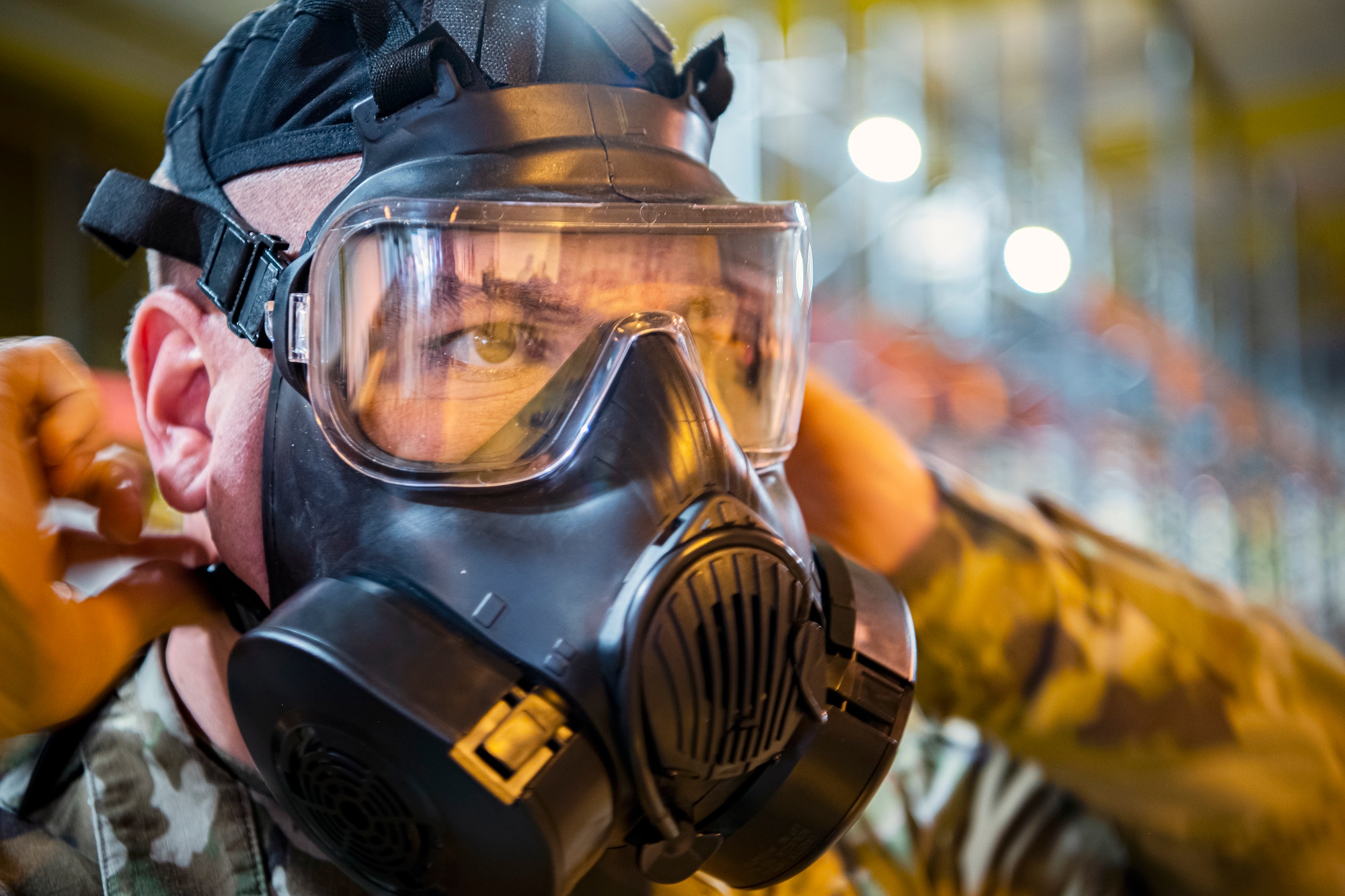 U.S. Air Force Senior Master Sgt. Kyle Mullen, 423d Communications Squadron superintendent, adjusts his gas mask during Ability to Survive and Operate training at RAF Alconbury, England, Aug. 27, 2021. The ATSO rodeo was designed to reinforce Airmen’s ability to properly utilize their MOPP gear in a potential chemical environment. (U.S. Air Force photo by Senior Airman Eugene Oliver)