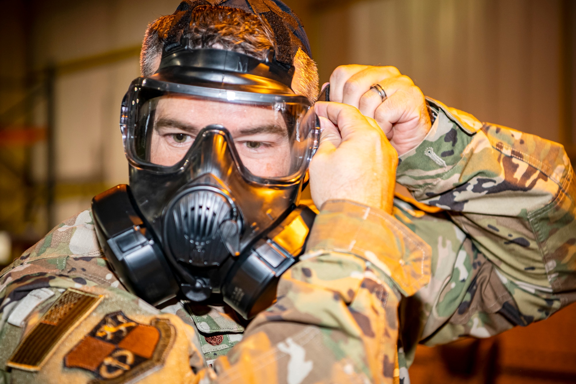 U.S. Air Force Col. Brian Filler, 501st Combat Support Wing commander, adjusts his gas mask during Ability to Survive and Operate training at RAF Alconbury, England, Aug. 27, 2021. Filler along with other Airmen from the 501st CSW participated in the ATSO rodeo to get a refresher on how to properly utilize their MOPP gear in a potential chemical environment. (U.S. Air Force photo by Senior Airman Eugene Oliver)