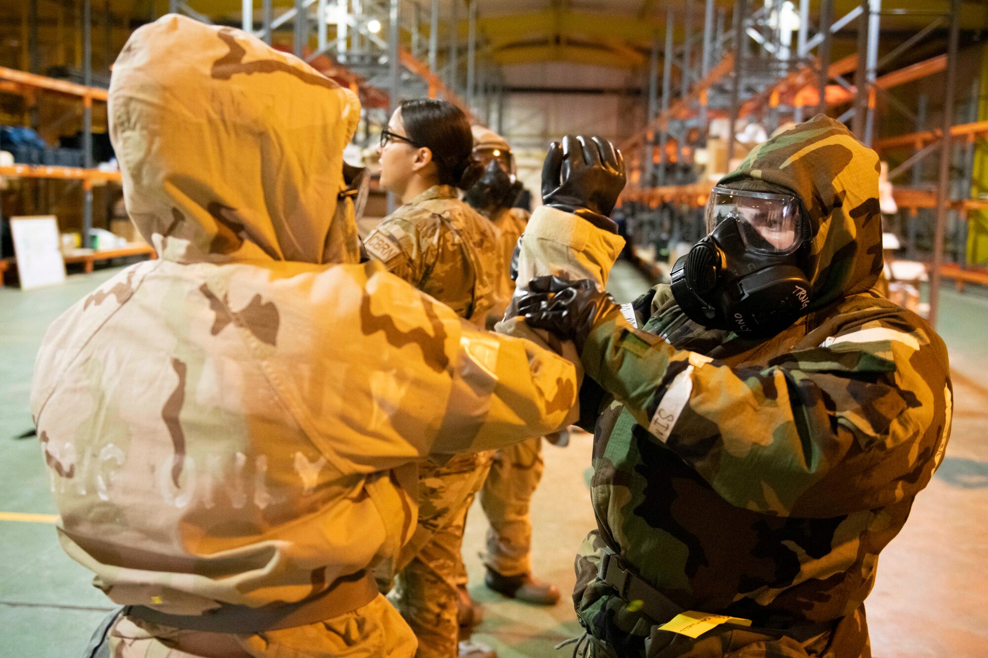 Airmen from the 501st Combat Support Wing don their Mission Oriented Protective Posture gear during Ability to Survive and Operate training at RAF Alconbury, England, Aug. 26, 2021. Airmen participated in the ATSO rodeo to get a refresher on how to properly utilize their MOPP gear in a potential chemical environment. (U.S. Air Force photo by Senior Airman Jennifer Zima)