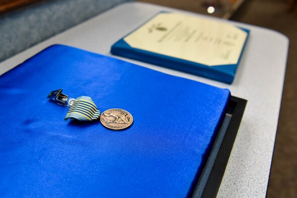 An Airman’s Medal, and order citation rests on a table