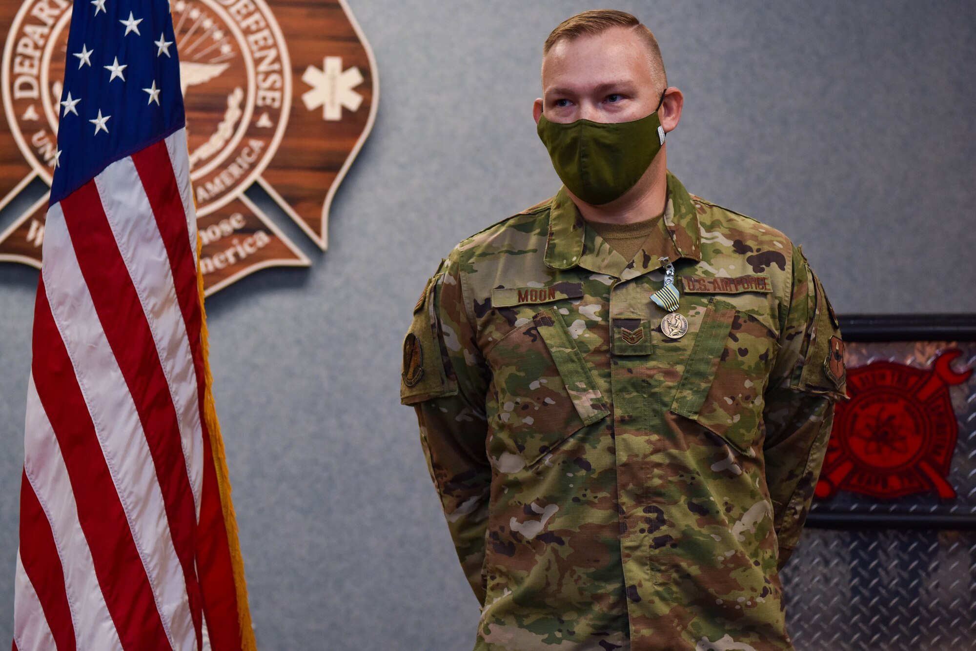 Airman Stands and delivers remarks during a medal ceremony.
