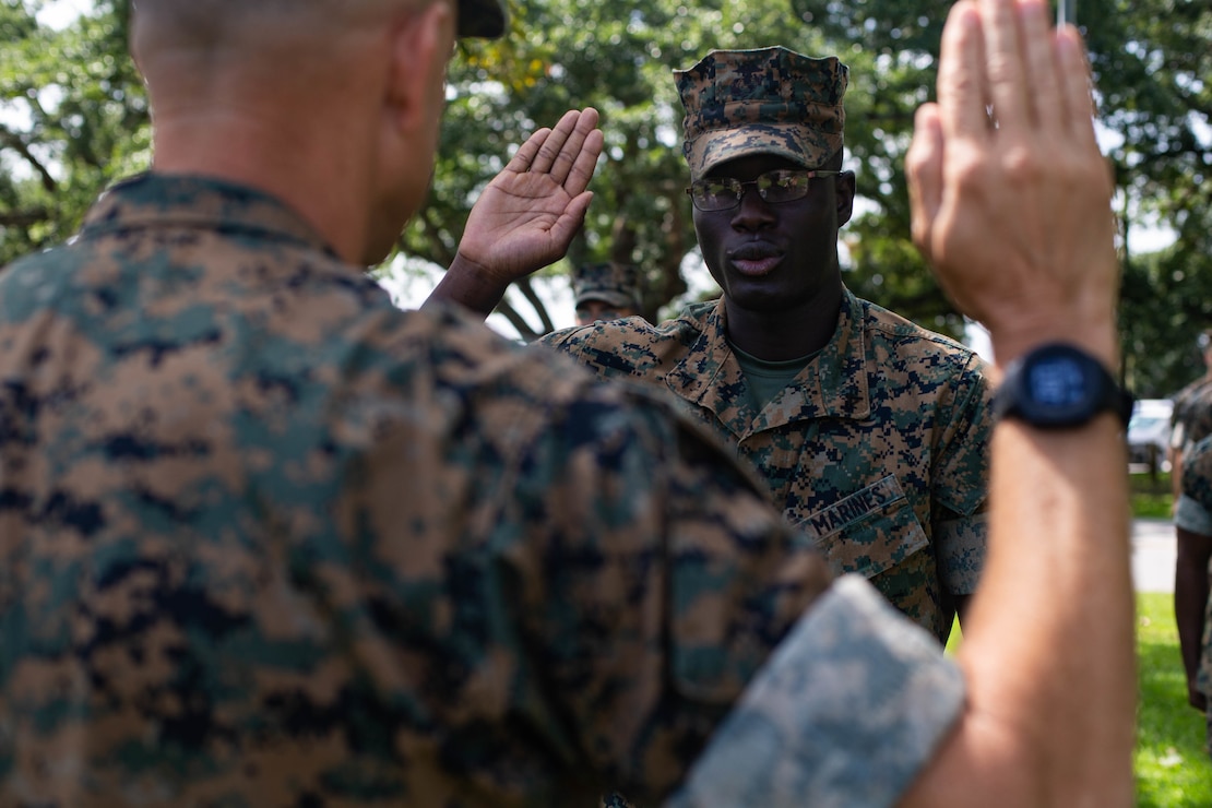 U.S. Marine Corps Lance Cpl. Anthonas Thermidor, a legal services specialist with Headquarters Battalion, 2d Marine Division, recites the oath of enlistment during a flag presentation ceremony at Camp Lejeune, N.C., Aug. 27, 2021. Thermidor, a Haitian native, received an American flag to commemorate earning American citizenship. (U.S. Marine Corps photo by Lance Cpl. Reine Whitaker)