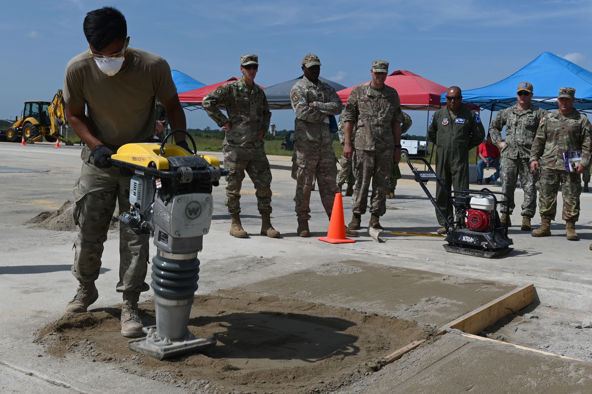 U.S. Air Force civil engineers from the pavements and construction equipment career field, from eight separate units, team up with U.S. Navy Seabees from the Naval Mobile Construction Battalion 133, Gulfport, Mississippi for an Expedient and Expeditionary Airfield Damage Repair (E-ADR) distinguished visitors’ demonstration at McEntire Joint National Guard Base, South Carolina, Aug. 31, 2021. The purpose of the training is to provide just enough, just in time repair capability with minimal cost and materials in a wartime situation.  (U.S. Air National Guard photo by Senior Master Sgt. Edward Snyder, 169th Fighter Wing Public Affairs)