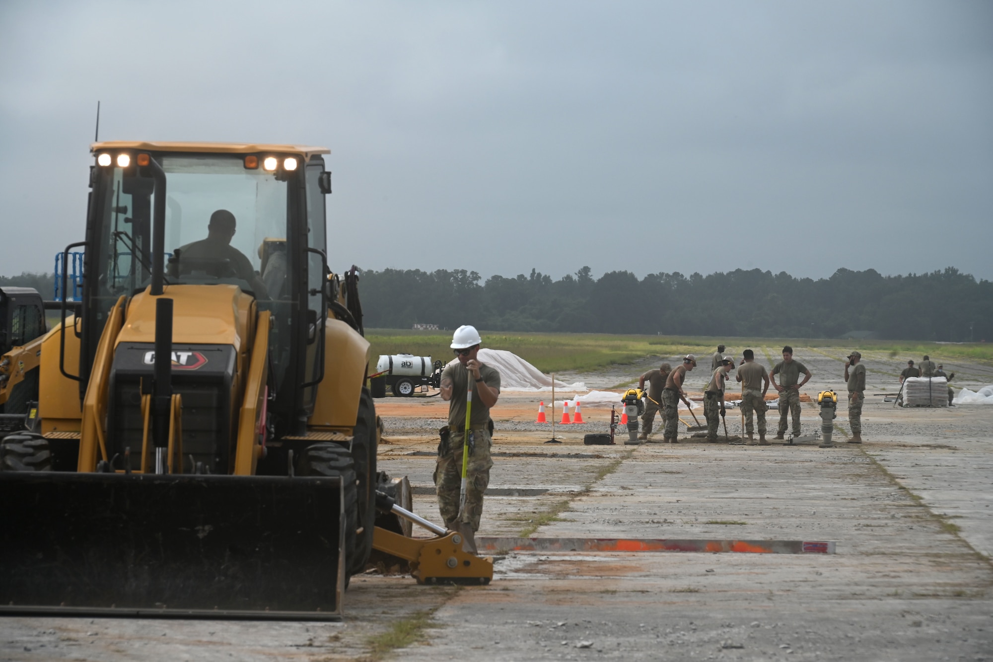 U.S. Air Force civil engineers from the pavements and construction equipment career field, known as the Dirt Boys from eight separate units, team up with U.S. Navy Seabees from the Naval Mobile Construction Battalion 133, Gulfport, Mississippi for an Expedient and Expeditionary Airfield Damage Repair (E-ADR) demonstration at McEntire Joint National Guard Base, South Carolina, Aug. 27, 2021. The purpose of the training is to provide just enough, just in time repair capability with minimal cost and materials in a wartime situation.  (U.S. Air National Guard photo by Senior Master Sgt. Edward Snyder, 169th Fighter Wing Public Affairs)